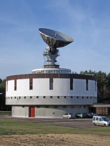 Historic Neu Golm earth station with a large parabolic antenna mounted on its circular operations building.